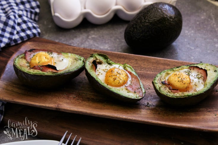 Avocado Egg Bake - Baked avocadoes on a wooden serving dish - Breakfast Avocados