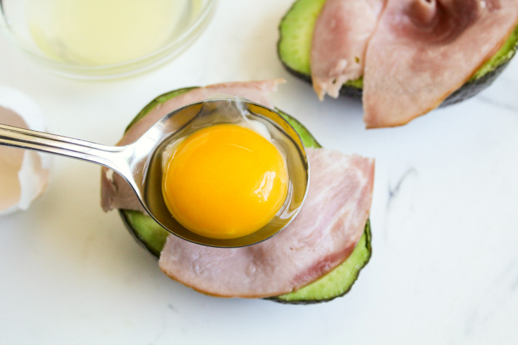Avocado Egg Bake - placing egg yolk in avocado