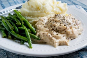 Crockpot Chicken and Gravy - Slow cooker chicken gravy served on a white plate