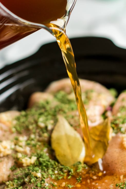 pouring broth into slow cooker