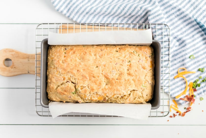 Bacon Cheddar Irish Soda Bread - Baked bread in a loaf pan cooling on wire rack