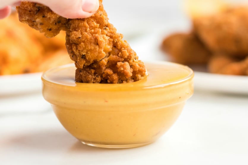 Copycat Chick Fil A Sauce - Dipping chicken tender in sauce - Family Fresh Meals