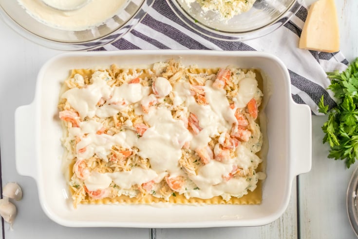 Easy Seafood Lasagna - Creamy sauce placed over seafood - Family Fresh Meals