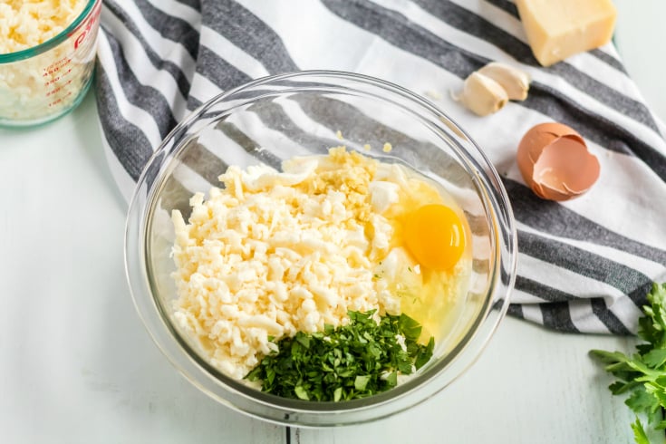 Easy Seafood Lasagna - egg, seasoning and cheese in a glass bowl - Family Fresh Meals