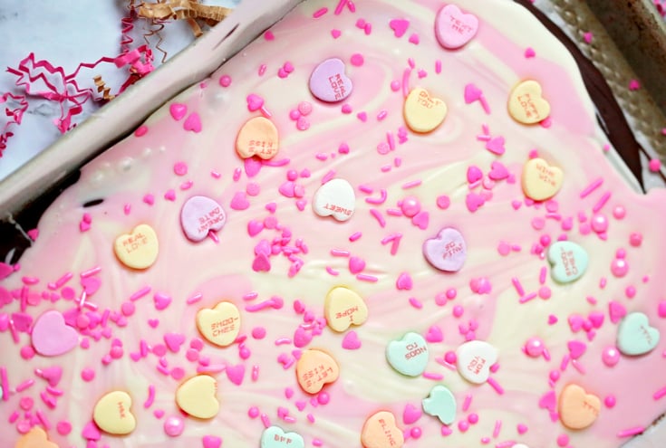 Valentine's Day Chocolate Bark - Conversation hearts and sprinkles on top of melted candy melts.