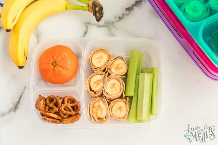 Banana Roll Up Lunch Box Idea - Packed in Easy Lunchboxes with celery, orange and pretzels - Family Fresh Meals