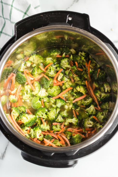 Instant Pot Broccoli Cheddar Soup -broccoli florets, carrots, oinon, broth and seasonings in pressure cooker - Family Fresh Meals