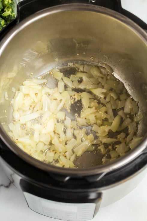 Instant Pot Broccoli Cheddar Soup - onions sauting in pressure cooker - Family Fresh Meals