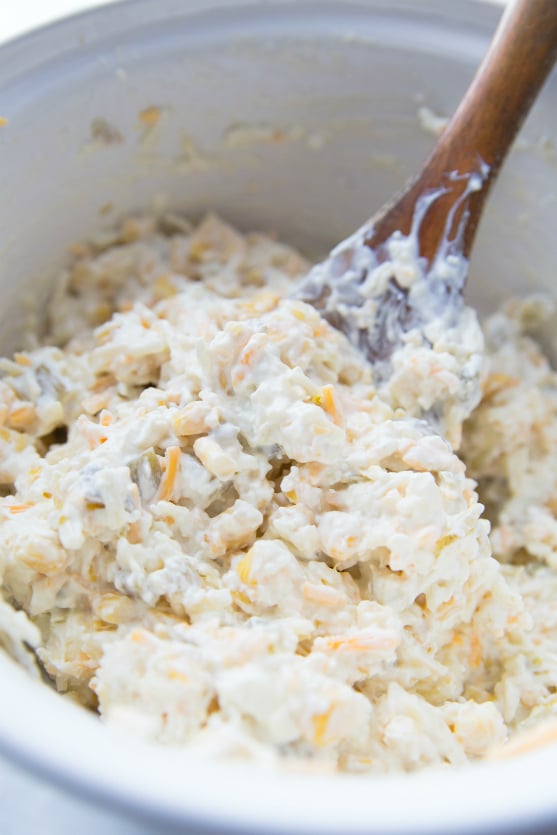 Creamy Fiesta Chicken Bake - creamy mixture being mixed in white bowl