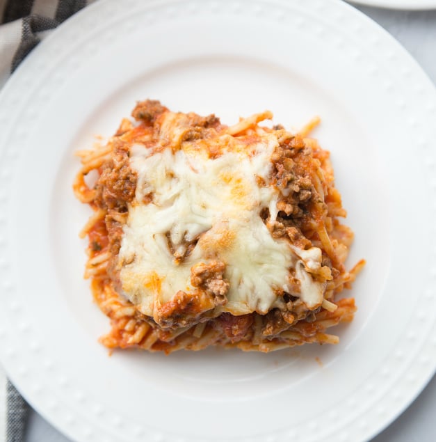 Million Dollar Baked Spaghetti - spaghetti bake served on a white plate