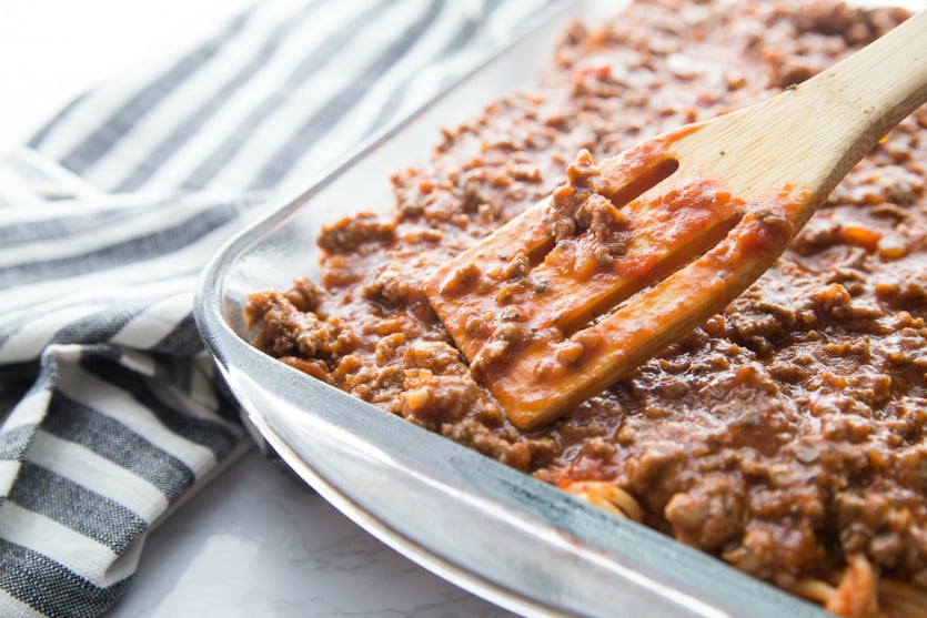 Million Dollar Baked Spaghetti - spreading meat sauce on top of spaghetti bake