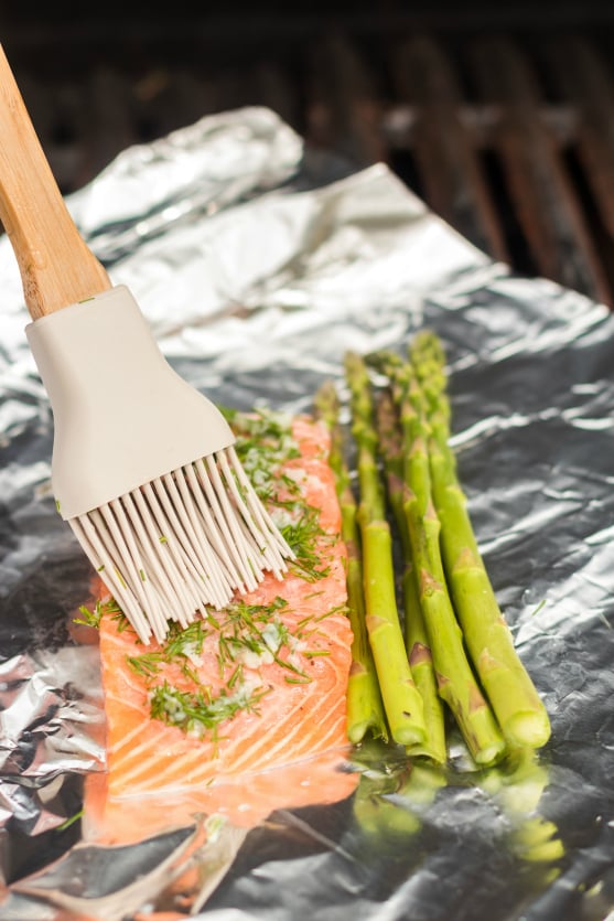 Asparagus Salmon Foil Packets - Brushing dill and garlic on salmon - on the grill