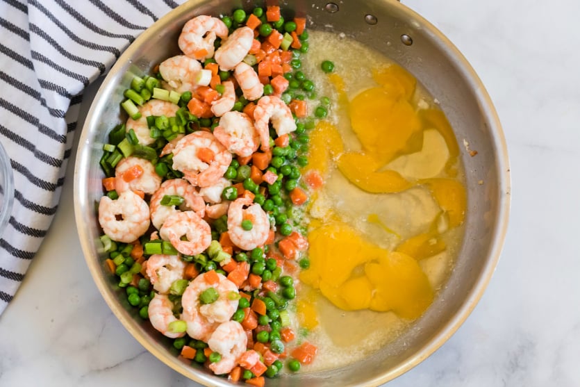 Easy Shrimp Fried Rice - adding egg to one half of pan - Family Fresh Meals