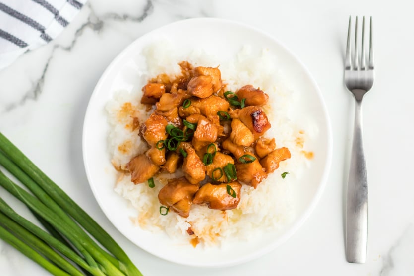 Instant Pot Orange Chicken - plated with white rice and topped with green onions