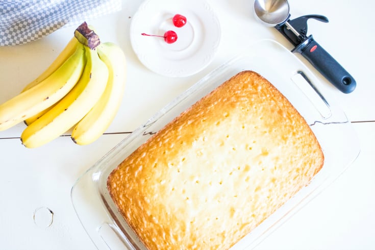 Banana Split Poke Cake - cooked white cake with holes poked in it