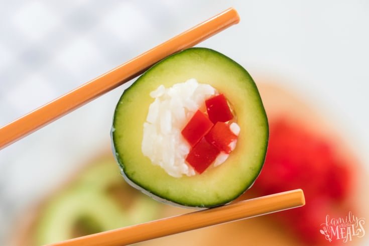 Cucumber Sushi Lunch Box Idea - holding a piece of cucumber sushi with chopsticks