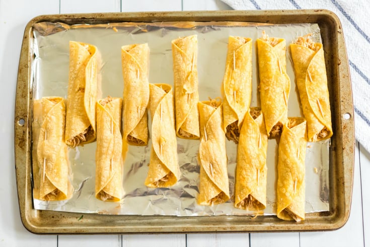 Easy Chicken Taquitos - rolled up taquitos on a baking sheet