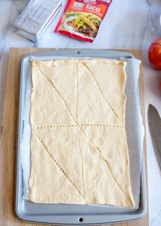 Easy Fiesta Taco Pizza - Ingredients- crescent dough rolled out on a sheet pan