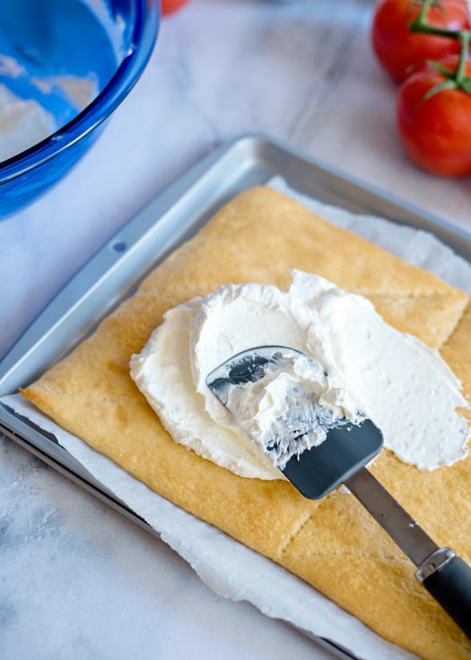 Easy Fiesta Taco Pizza - Spreading cream mixture over cooked dough