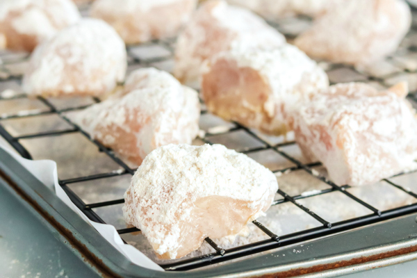 Copycat Chick Fil A Nuggets - Chicken covered in batter and on a drying rack