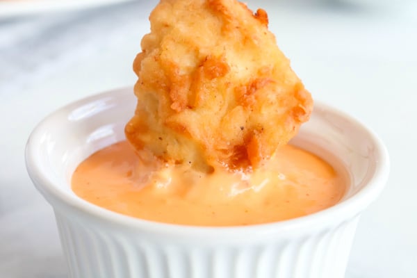 Copycat Chick Fil A Nuggets - dipping chicken nugget in chick fil a sauce