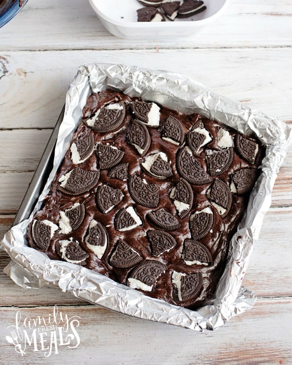 Oreo Stuffed Brownies - Placing broken oreo cookie pieces on to of brownie batter