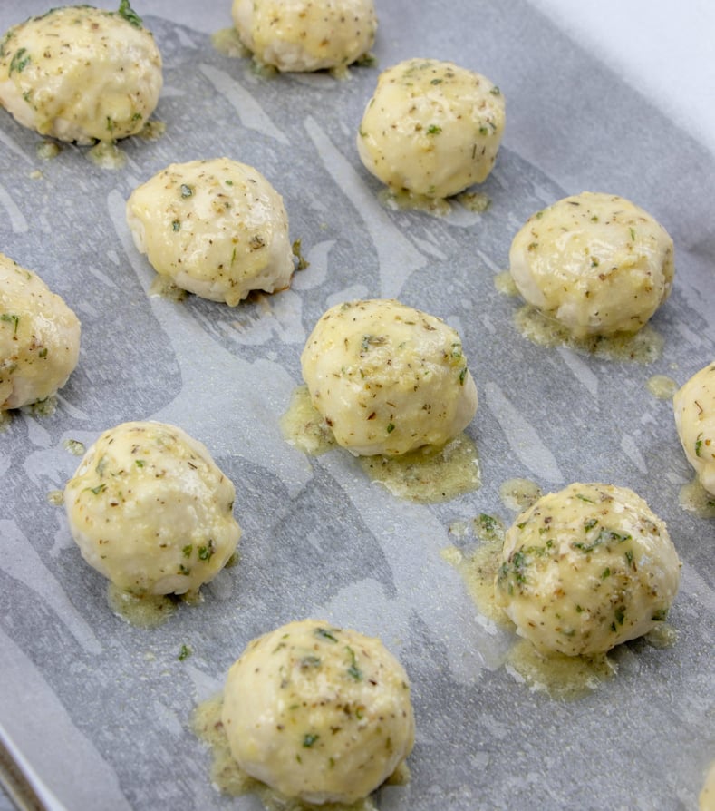 Cheesy Pizza Bombs - Dough balls on baking sheet brushed with butter
