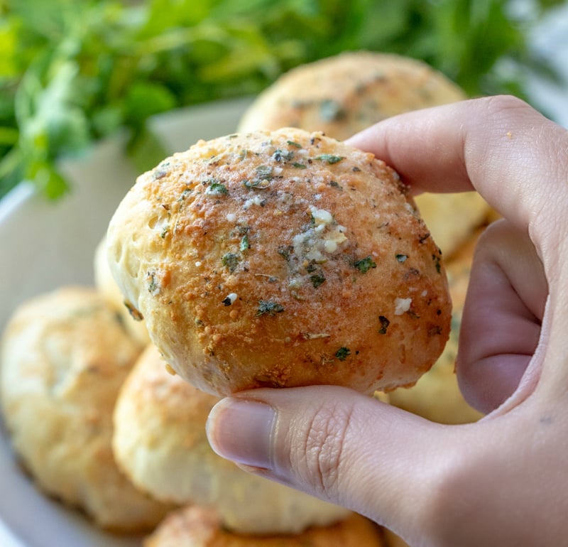 Cheesy Pizza Bombs - hand holding a cheesy pizza bomb