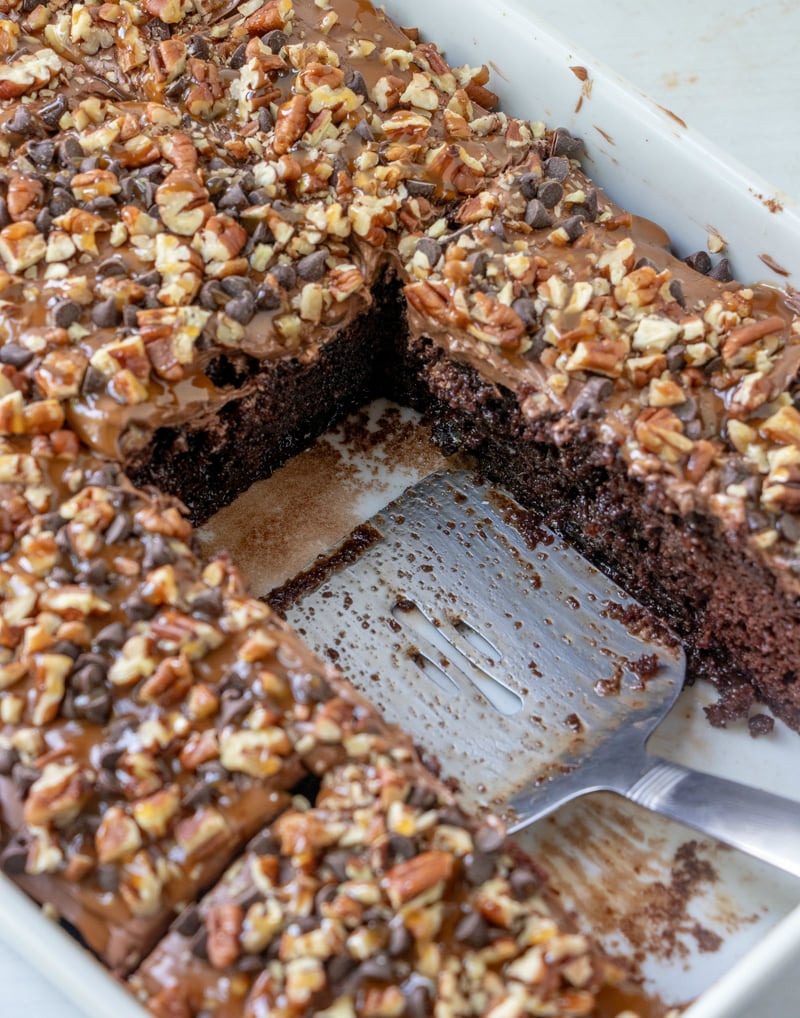 Chocolate Turtle Poke Cake - serving pieces of cake