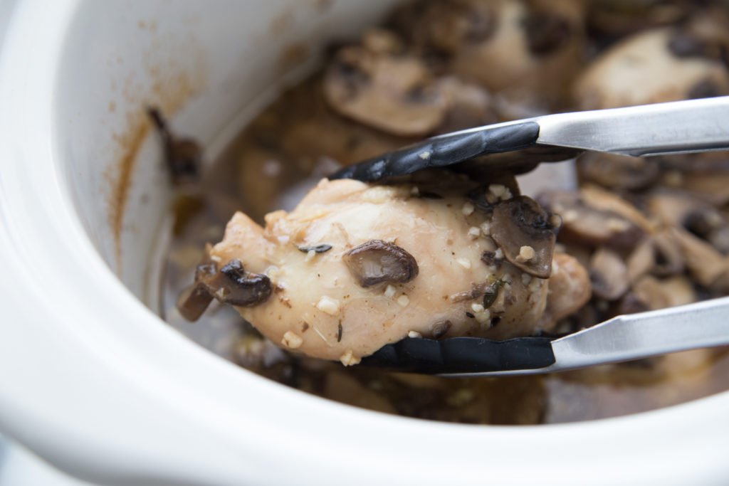 Crockpot Chicken Marsala - picking up chicken with thongs