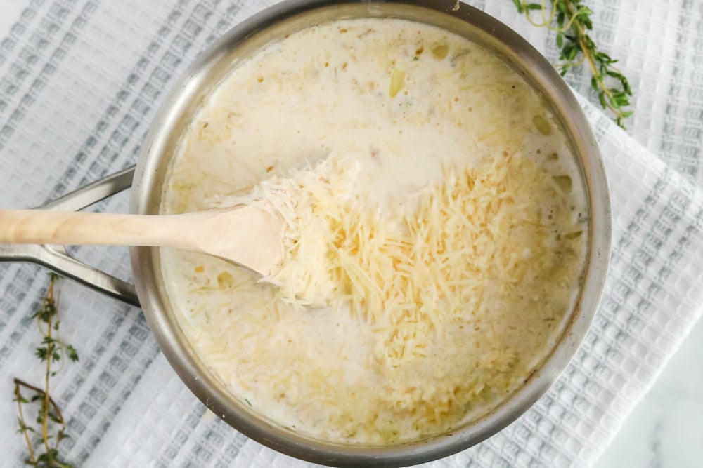 Creamy Potatoes Au Gratin - adding in shredded cheese to pot