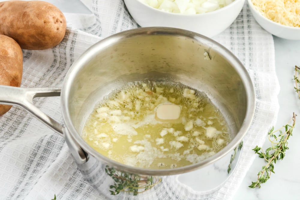 Creamy Potatoes Au Gratin - butter, onions and garlic in sauce pan