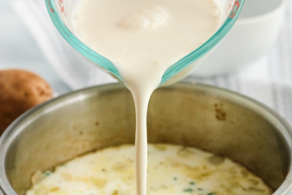 Creamy Potatoes Au Gratin - pouring in heavy cream