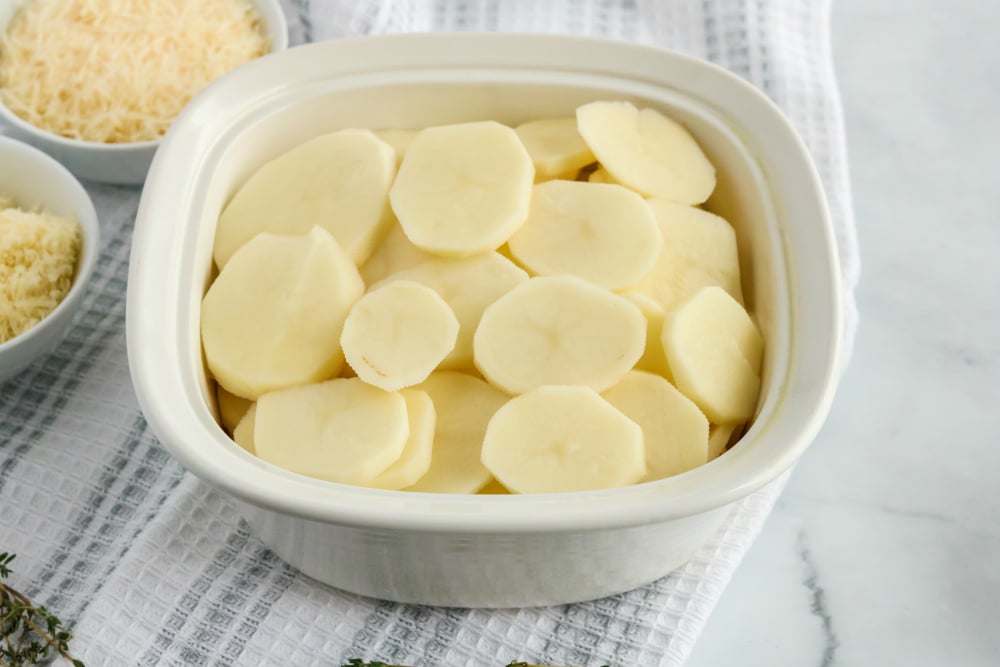 Creamy Potatoes Au Gratin - sliced potatoes in a square baking dish
