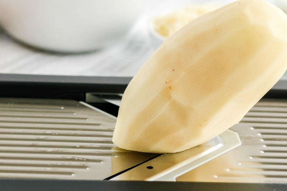 Creamy Potatoes Au Gratin - slicing potatoes with mandoline slicer