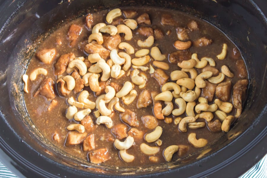Crockpot Cashew Chicken - cashews being added into the slow cooker