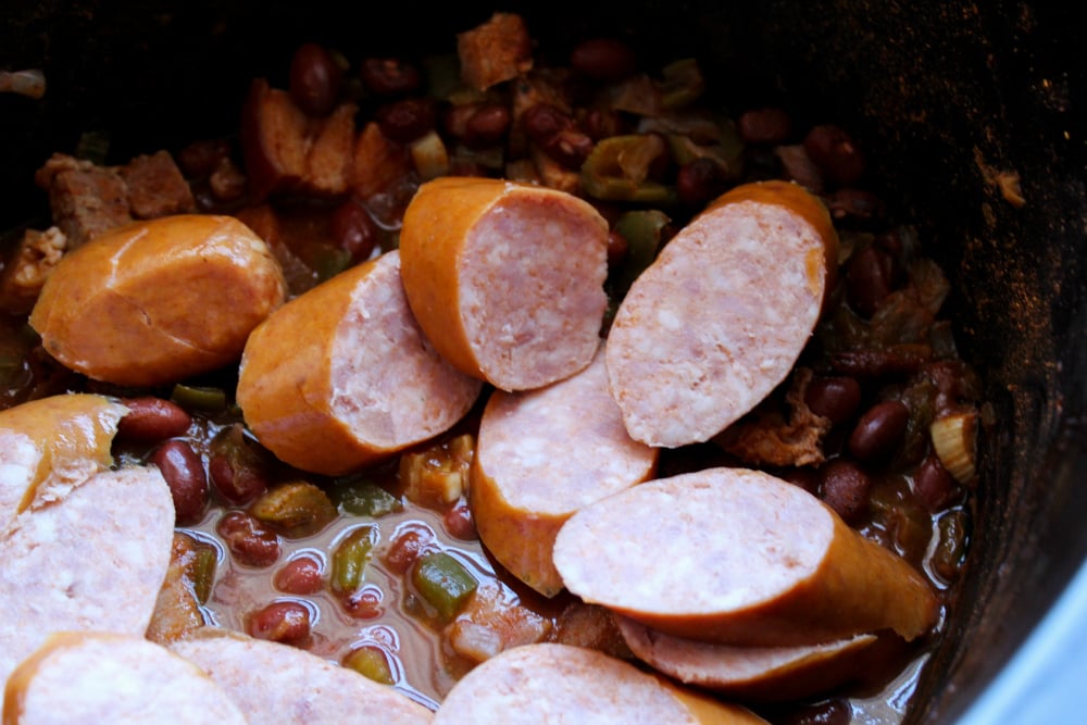 Crockpot Red Beans and Rice - sausage being added into slow cooker