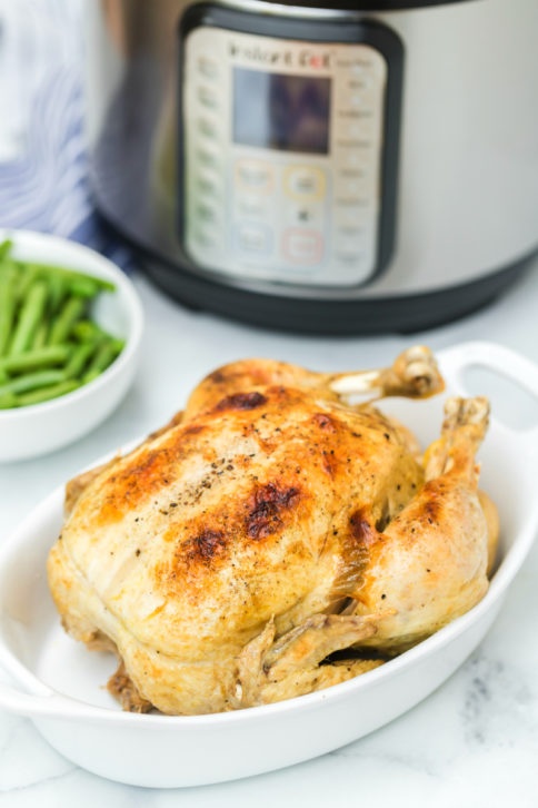 Instant Pot Dill Pickle Chicken Recipe - Cooked whole chicken in white baking dish