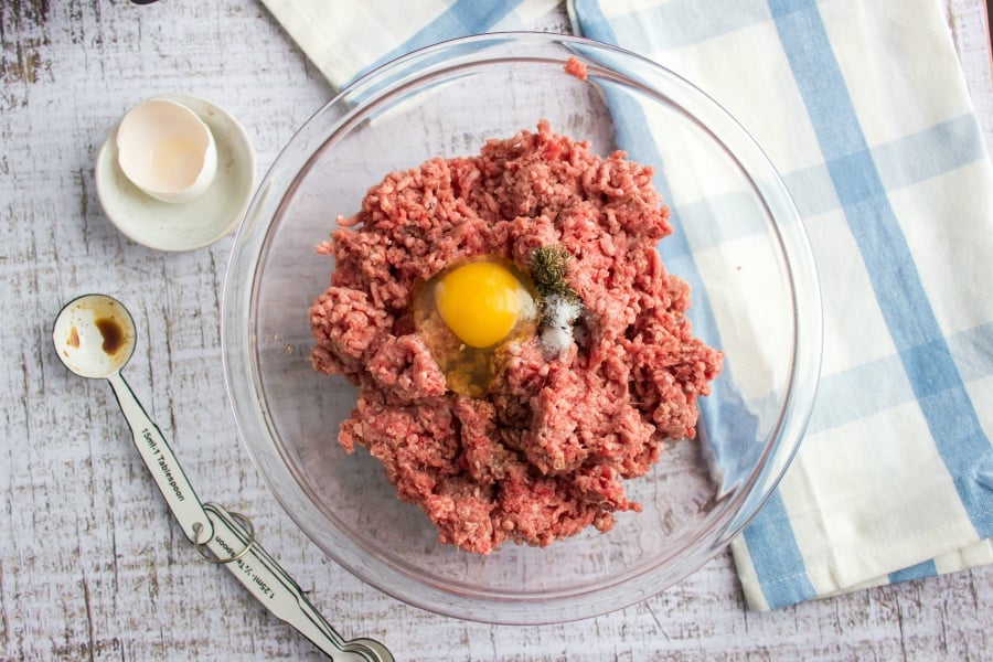 Air Fryer Cheeseburgers - ground beef mixutre with egg and seasoning in glass mixing bowl
