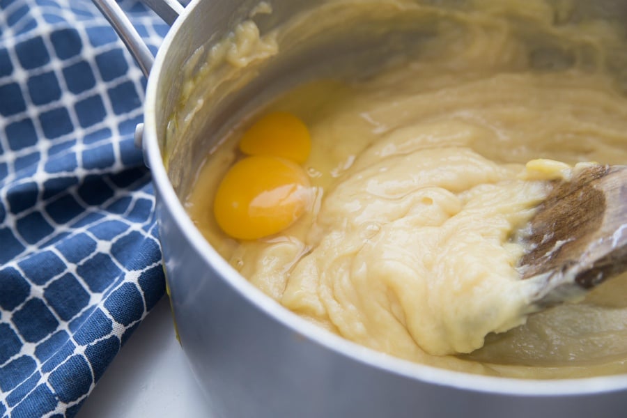 Easy Cream Puff Recipe - Stirring eggs into pastry dough in pot