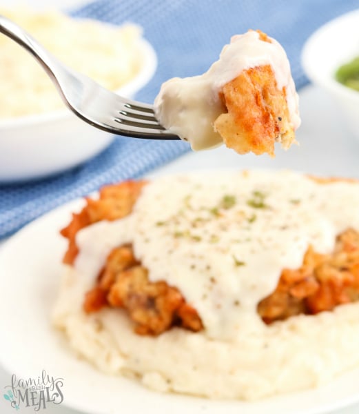 Chicken Fried Steak with White Gravy - fork holding piece of fried chicken cube steak