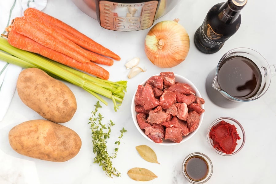 https://www.familyfreshmeals.com/wp-content/uploads/2020/03/Instant-Pot-Irish-Stew-ingredients-carrots-garlic-onion-guinness-broth-tomato-paste-bay-leaves-thyme-potatoes-celery.jpg