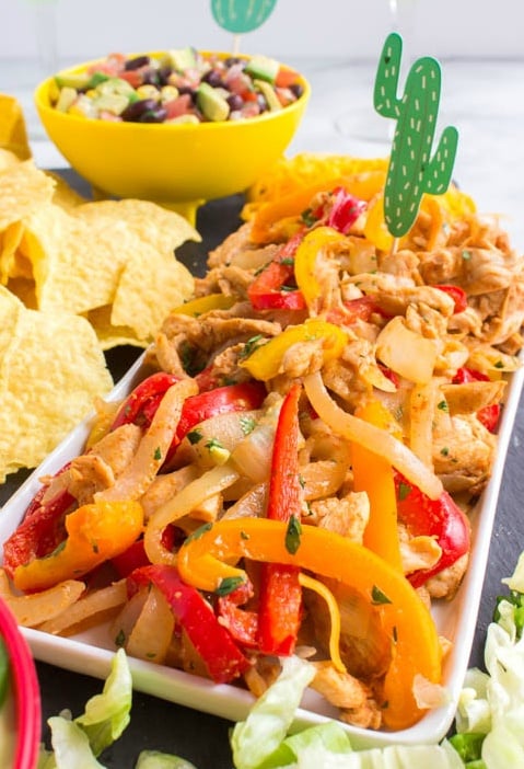 Chicken fajitas on a white platter