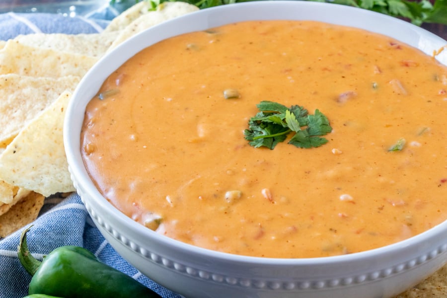 Copycat Chipotle Queso Dip Recipe - served in a white bowl with chips