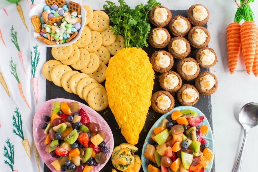 Snack board with cheese ball, carrot cake cups, bunny bait and glazed fruit