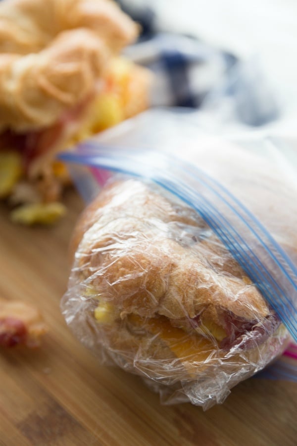 Freezer Friendly Breakfast Croissant Sandwiches - sandwiches wrapped in cling wrap and going in a ziplock bag