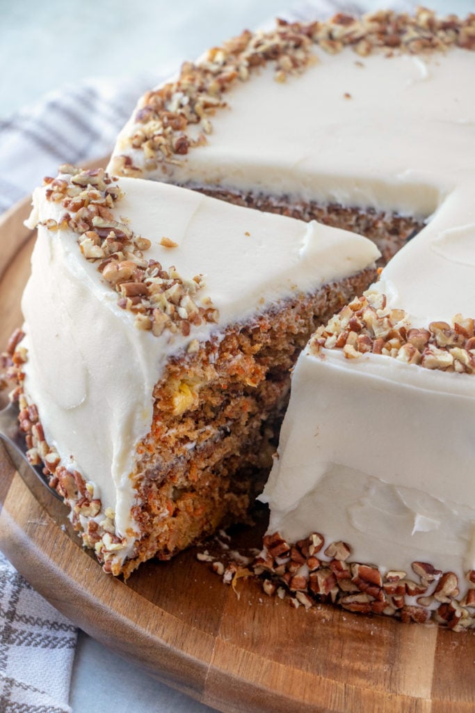 The Best Carrot Cake Recipe - cutting a slice of cake out of cake