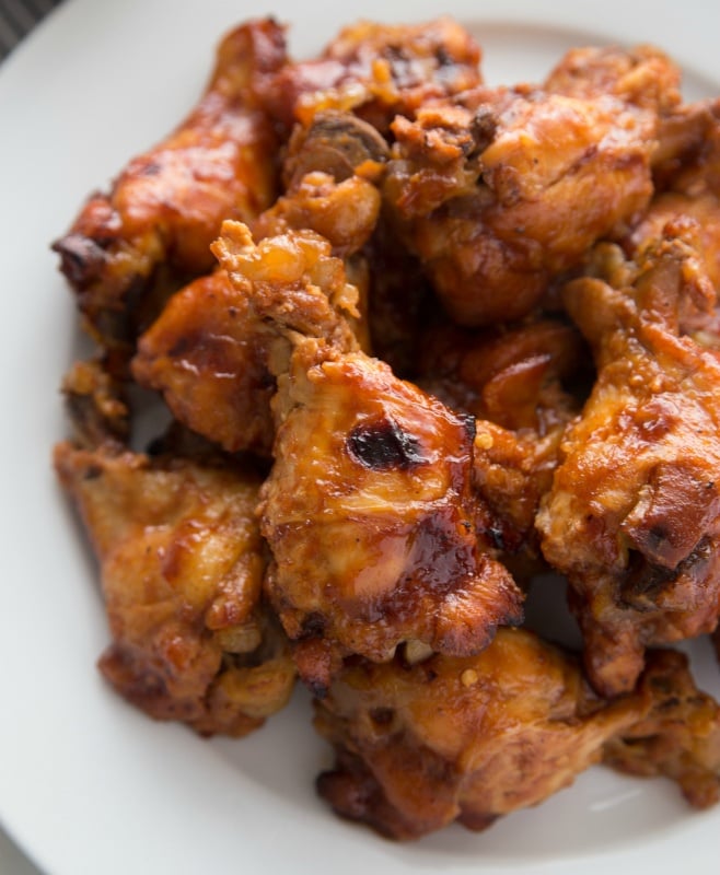 Crockpot Root Beer Chicken Wings stacked on a white plate