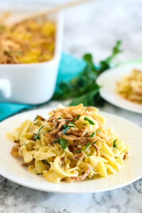 Casserole served on a white plate, and topped with fresh parsley
