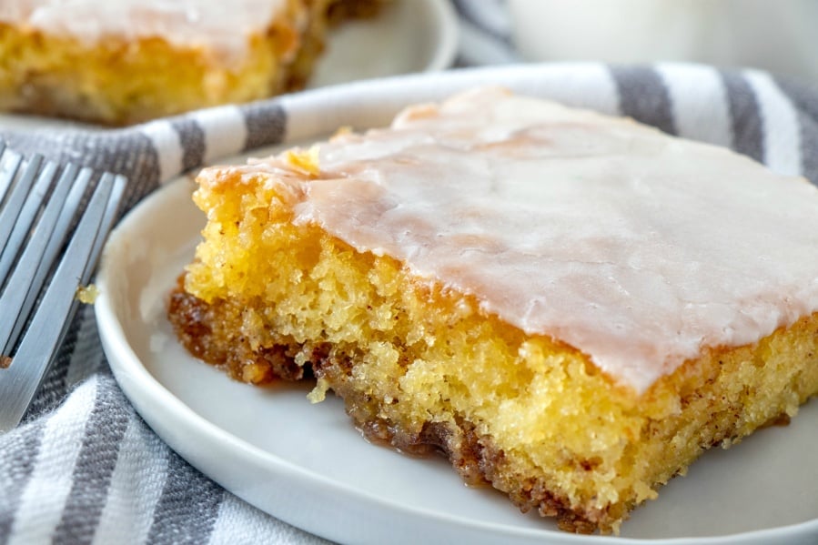 Slice of cake on a white plate with a fork next to the plate